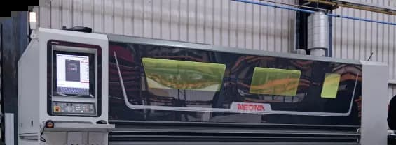 An industrial AMADA machine featuring tinted viewing windows and an integrated control interface screen.